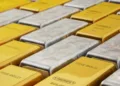 Precious metals ease as dollar firms; oil decline limits losses